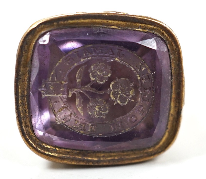 A 19th century yellow metal overlaid and amethyst set fob seal, the matrix carved with flowers and motto, 27mm.
